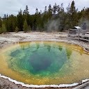 A hot spring with a green and yellow pool [Description automatically generated]